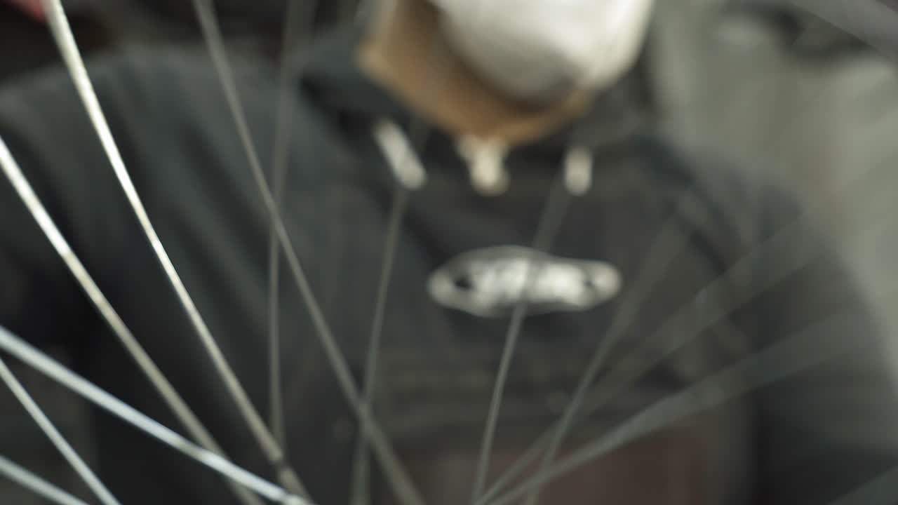 A bicycle mechanic repositioning a bicycle wheel tire