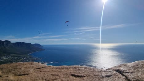 Gente-Volando-En-Parapente-En-Un-Cielo-Azul-Día-Soleado-Sobre-El-Océano-Atlántico