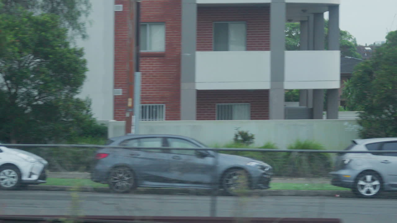 호주 시드니 의 집 들 과 건물 들 을 지나가는 새벽 에 열차 창문 에서 촬영