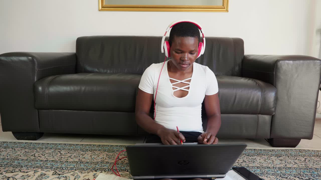 African lady working from home sitting on carpet