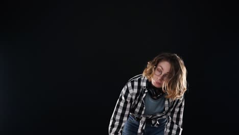 Cropped-footage-of-a-young-woman-sweeps-garbage-with-a-broom-in-the-scoop.-Cleaning-concept.-Isolated-over-black-background