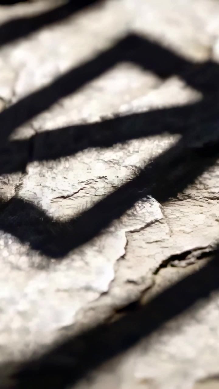Vertical video: Frame shifting, dark zigzag sliding across cracked plaster at macro, showing flakes
