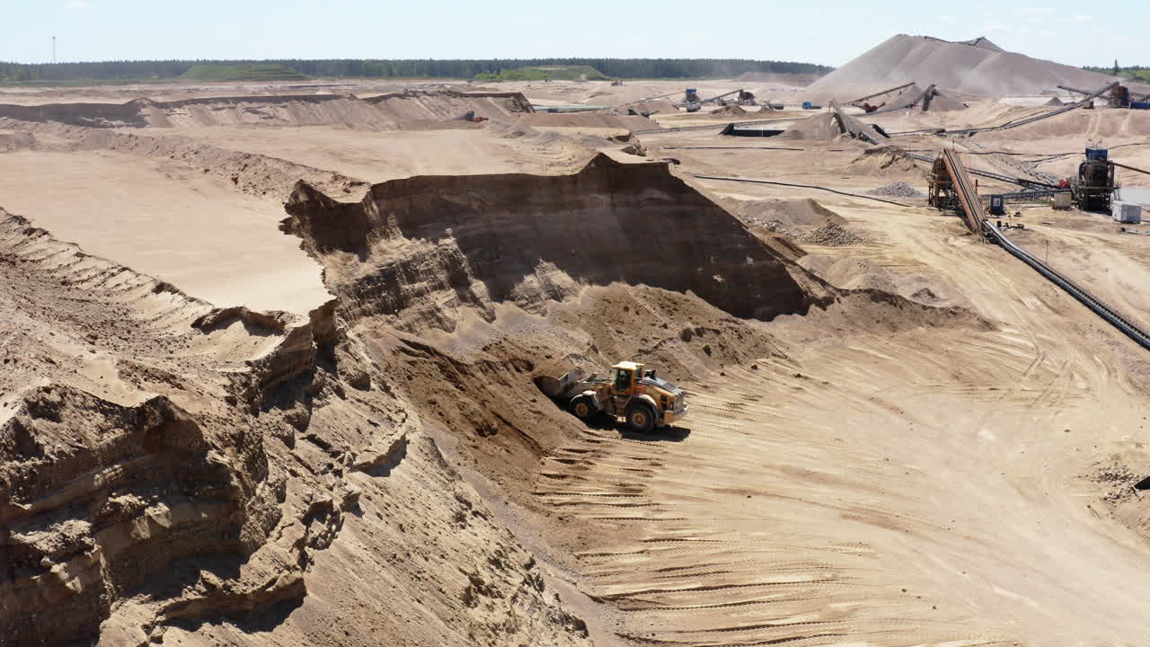 Front Loader Scooping Raw Materials At Sand Quarry Site. drone pullback ascend
