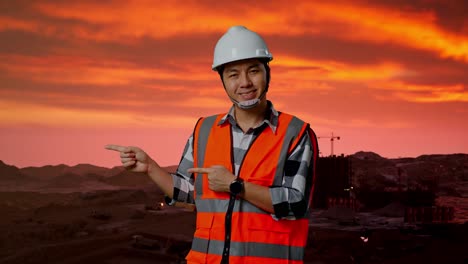 trabajador de la construcción señalando el sitio de construcción del atardecer