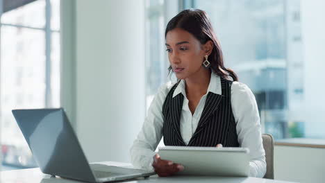 businesswoman working on laptop and tablet in office
