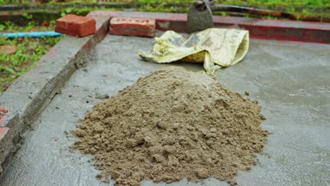 construction site in remote rural village in development in india mixing cement barefoot labor