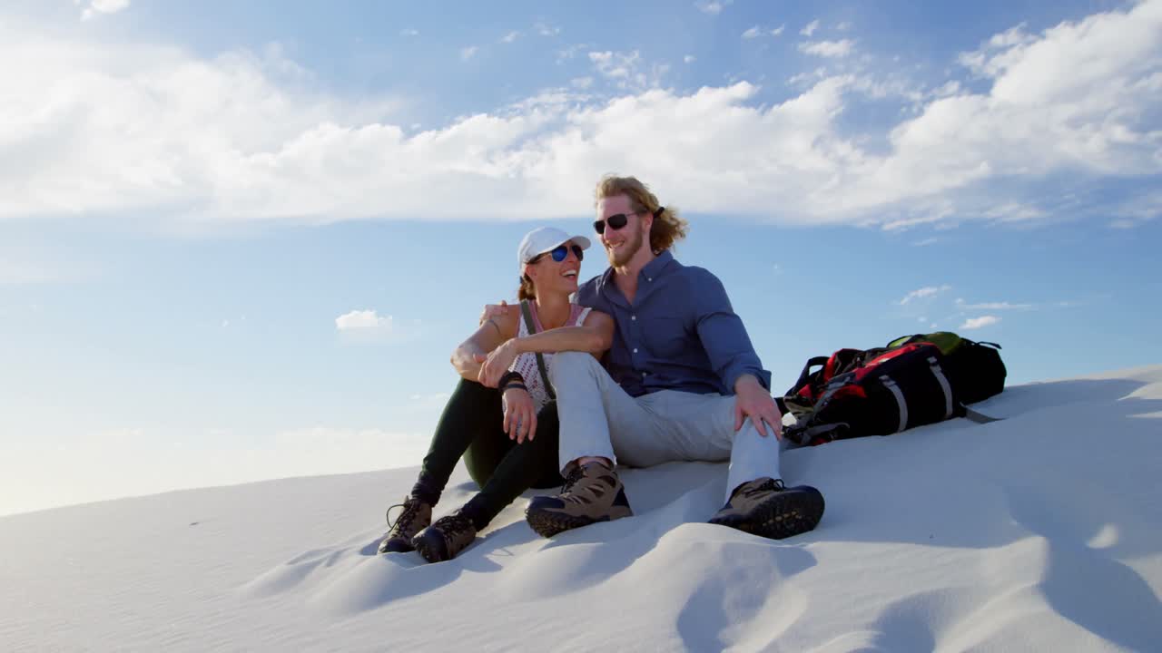 Coppia seduta che parla nel deserto 4k