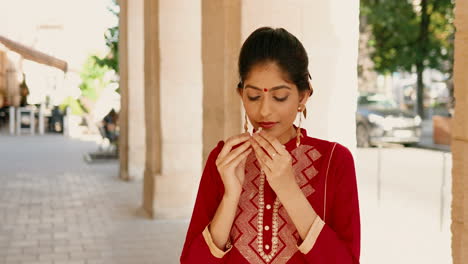 primer plano de una hermosa mujer india que huele una botella de perfume