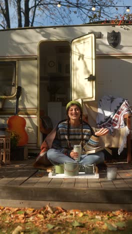 woman relaxing outdoors by a campervan in autumn