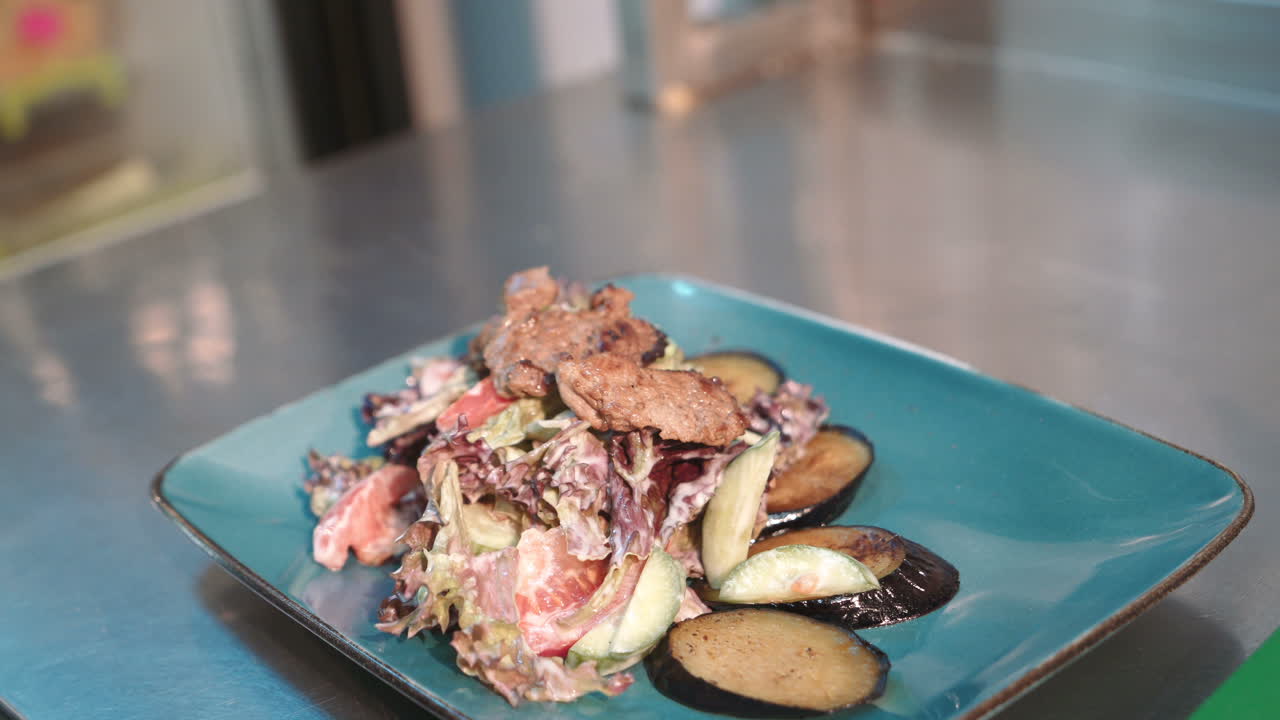 Preparing salad in restaurant. Close up of chef in process of making salad in restaurant
