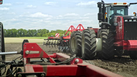 agricultural tractor driving on arable field for plowing land. farming industry