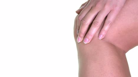 un primer plano de una mujer frotándose la rodilla, tratando de aliviar el dolor-inflamación