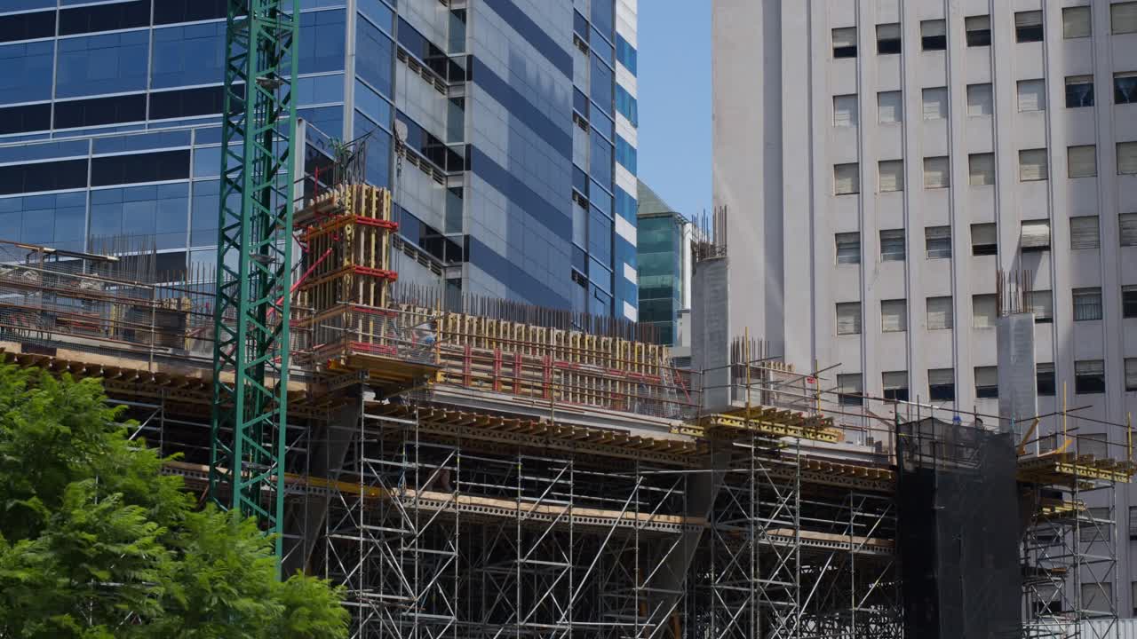 un sitio de construcción con una grúa y un marco de acero en la ciudad, que muestra el desarrollo urbano