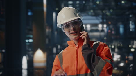 un técnico de la planta sonriente llamando al teléfono celular en el almacén de la fábrica de cerca.