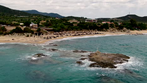 aerial static shot of luxury resort by azure ocean surrounded by amazing landscape and golden beach