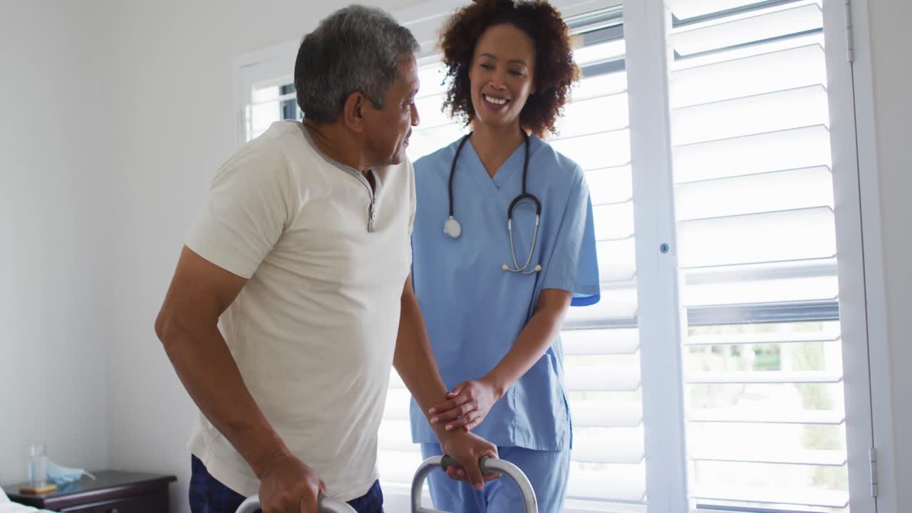 Mixed race female doctor home visiting helping senior patient get up