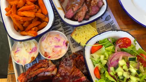carne de res con ensalada, costillas de cerdo con patatas fritas, pan de maíz y ensalada de col, comida tradicional estadounidense, gran comida familiar, tiro de 4k