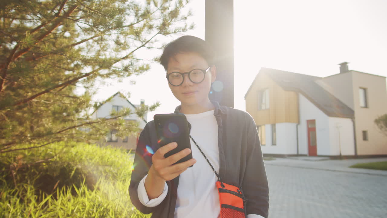 길거리에 서서  ⁇ 드폰을 사용하는 아시아 여성