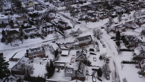 an aerial view over a suburban neighborhood in the morning, after a snow storm