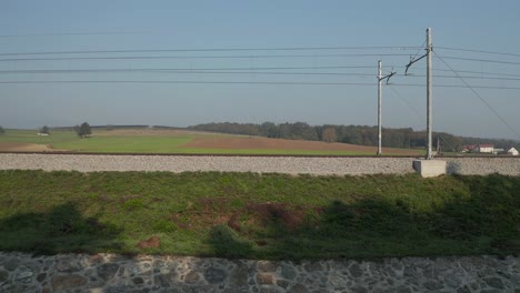 Panning-shot-of-an-empty-railroad-in-the-Slovenian-countryside-on-a-sunny-day