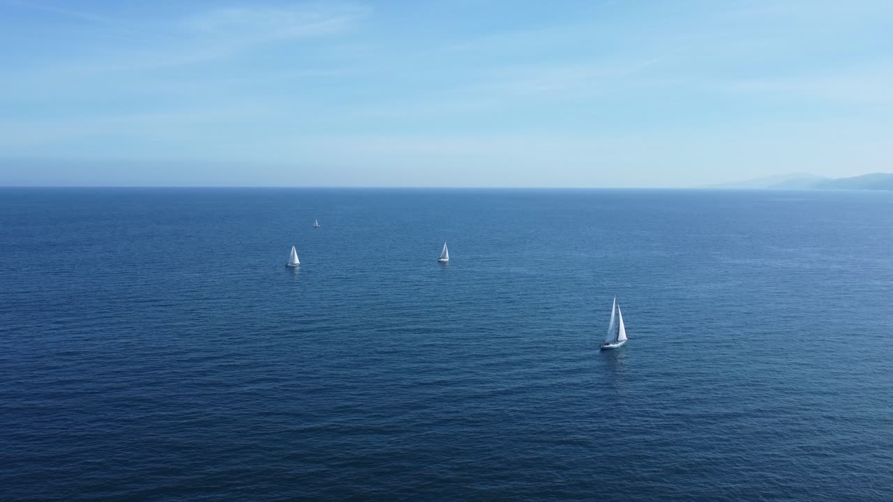 veleros blancos navegan en las tranquilas aguas azules de la bahía de biscay en el norte de españa