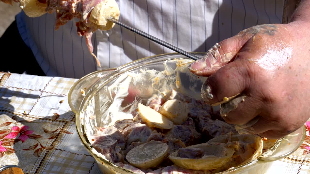 Fat Man Puts the Pickled Meat on a Skewer for a Shish Kebab