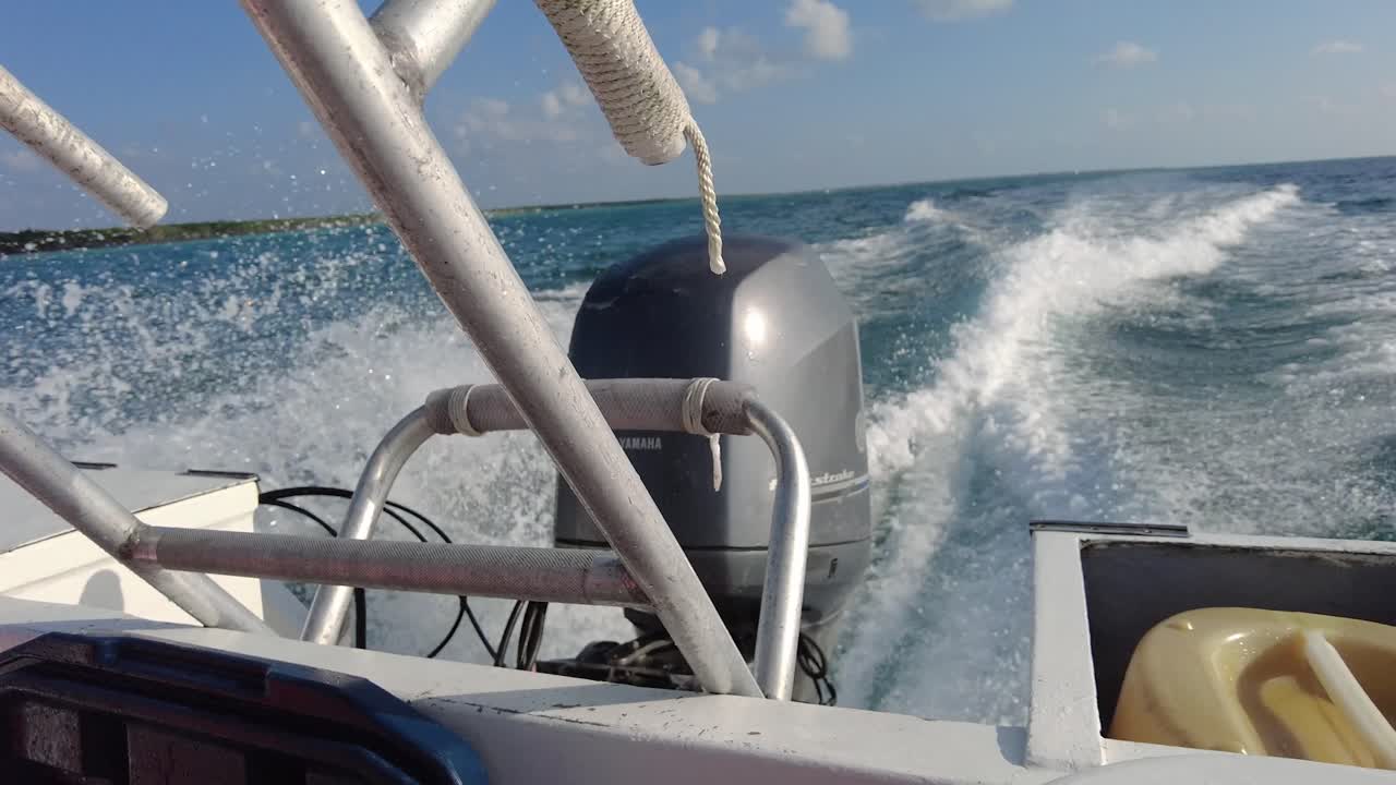 Lancha motora navegando entre las olas, la embarcación acelera, dejando un rastro de espuma blanca a su paso.