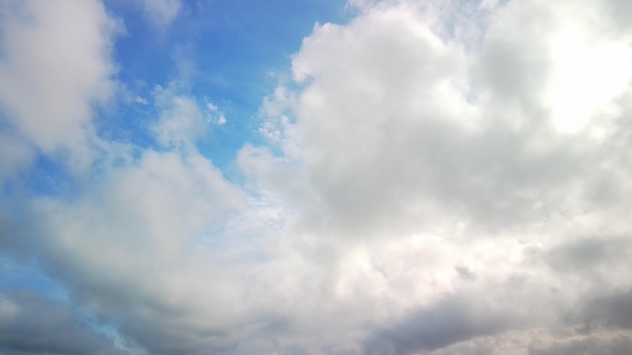 하늘을 가로질러 부드럽게 미끄러지는 구름의 평온한 아름다움을 포착하여 평온하고 끊임없이 변화하는 장면을 그립니다.