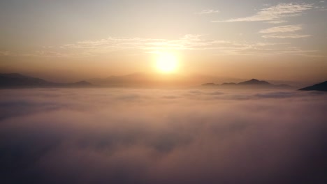 Amazing-rising-drone-shot-in-between-clouds-of-a-sunrise-in-the-hills-of-the-desert-of-Lima