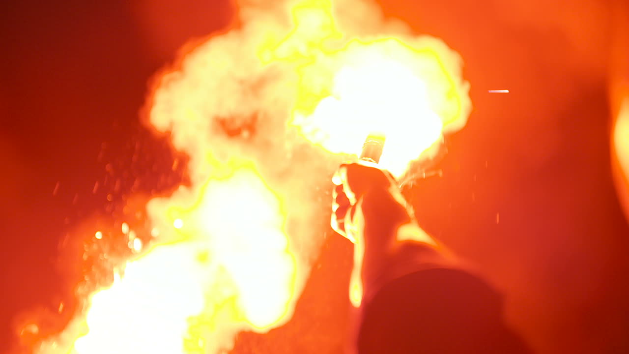 primer plano de una bengala de señal ardiendo sostenida por un hombre 2