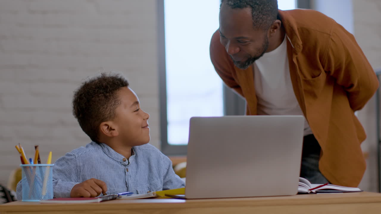 Father and Son Studying Together on Laptop
