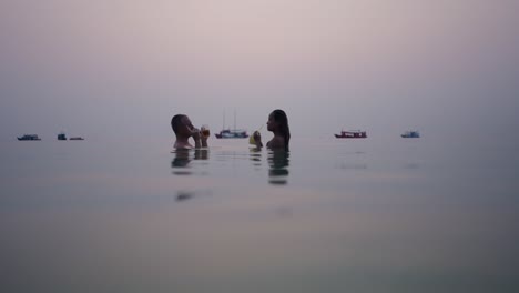 couple enjoying drinks in the water at sunset