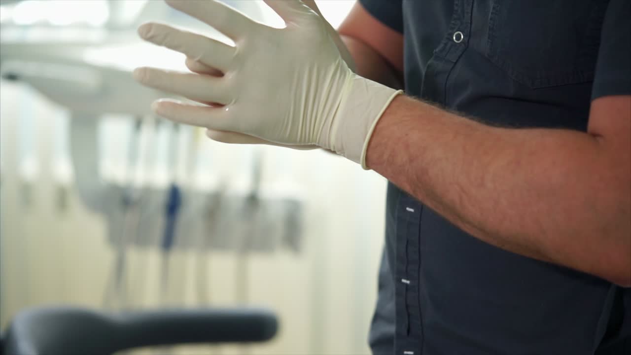 el dentista se pone los guantes.
