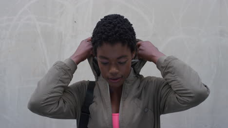 retrato hermosa joven mujer afroamericana sonriendo feliz se pone la capucha disfrutando de un estilo de vida urbano independiente serie de personas reales