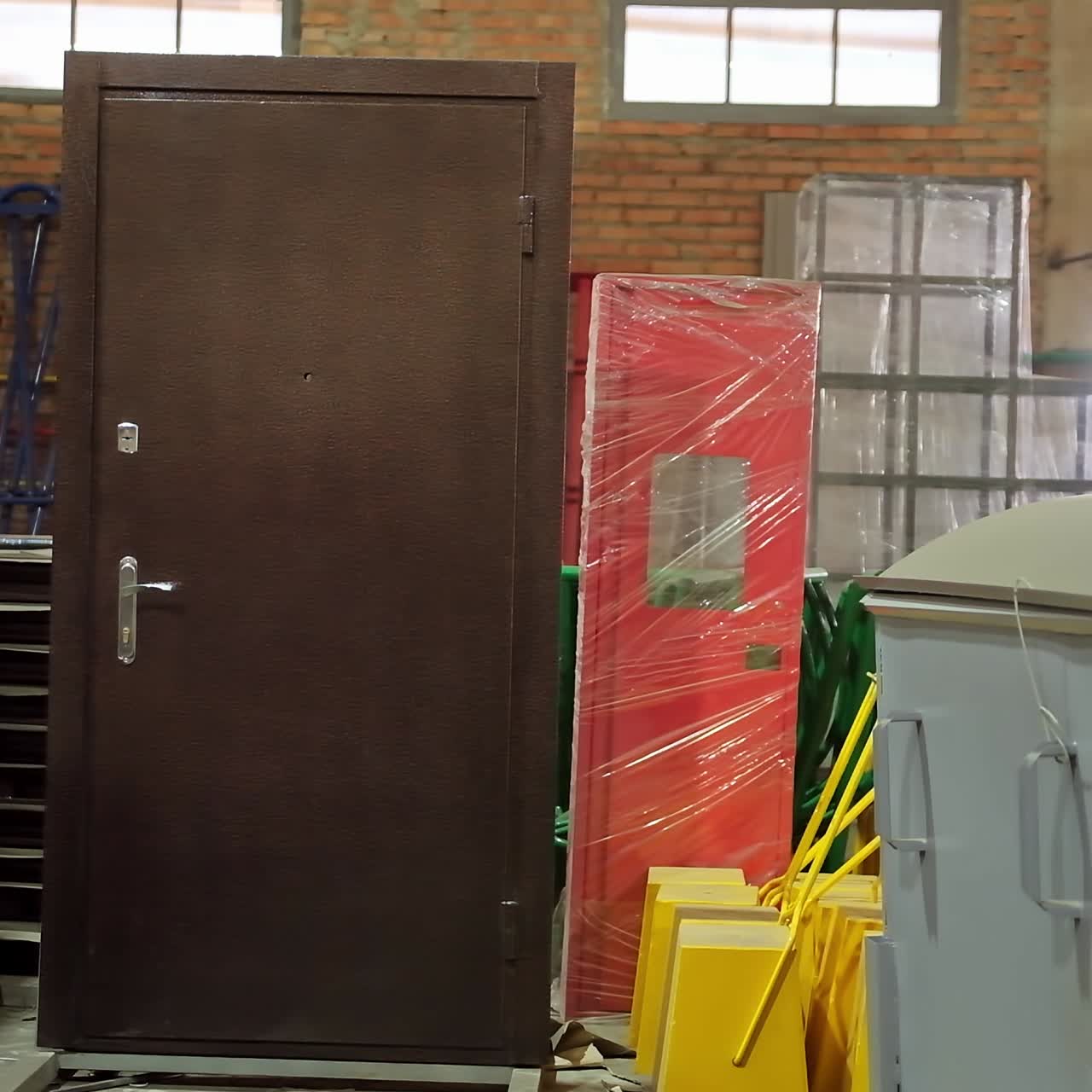Products at the warehouse. Interior of manufacturing with new metal doors and garbage bins. Industrial materials inside the plant.