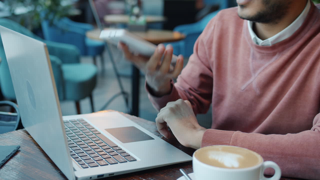 Man working on laptop in a cafe
