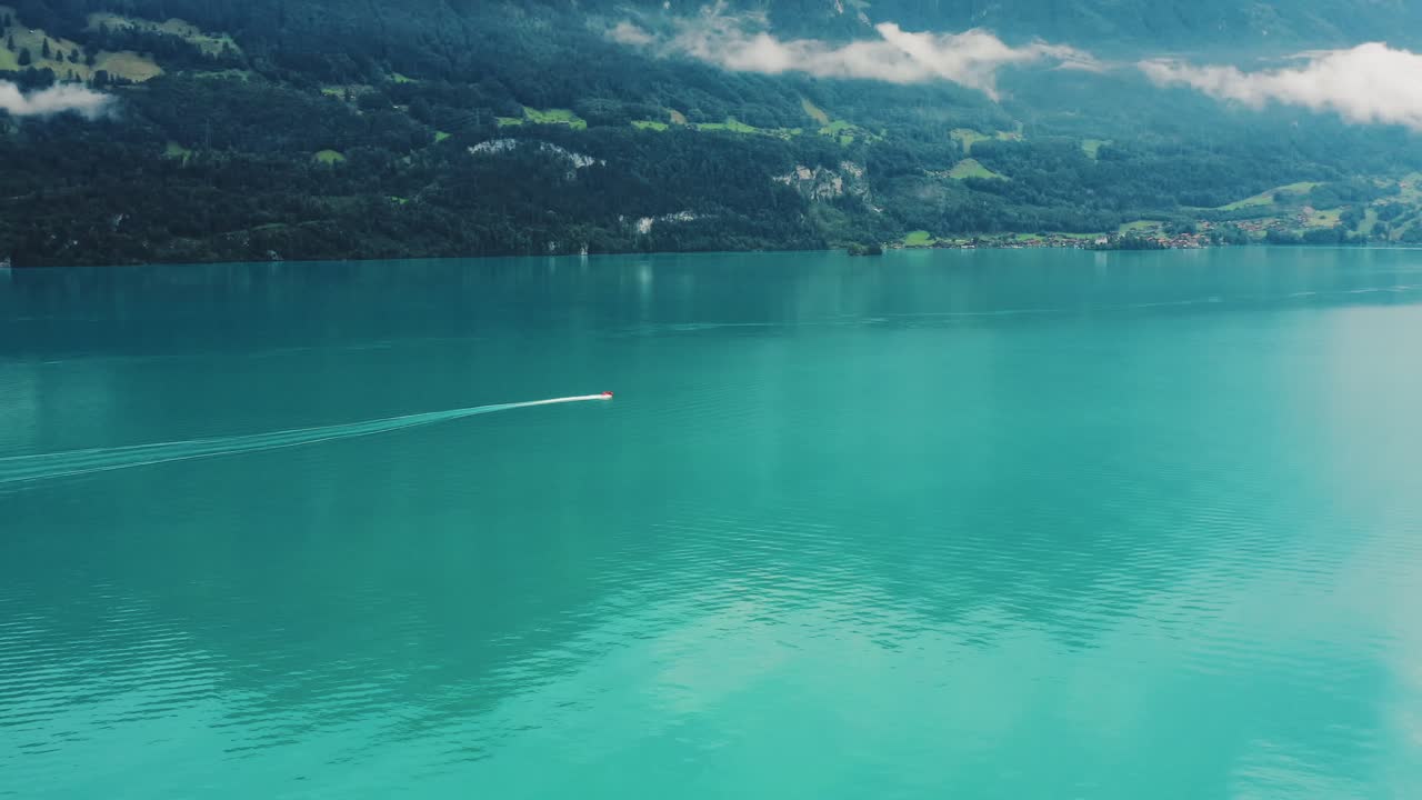 Kleines Boot erkundet das wunderschöne blaue Wasser des Thunersees, Schweiz