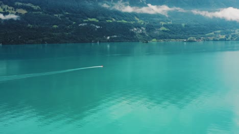 small boat exploring beautiful blue waters of lake thun, switzerland