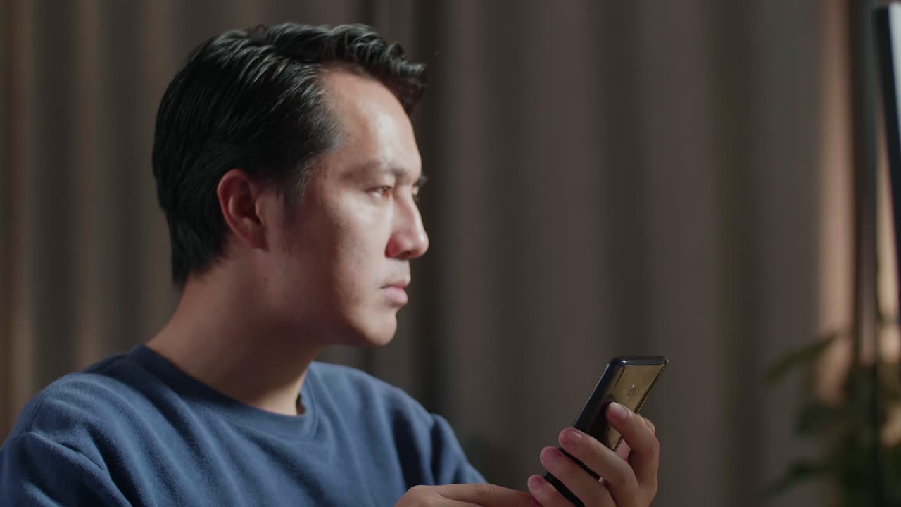 집에서 스마트폰을 사용하는 남자