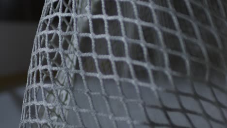 Extreme-Close-Up-Shot-Of-Ice-Hockey-Puck-Hitting-Net-And-Bouncing-Off-During-Game