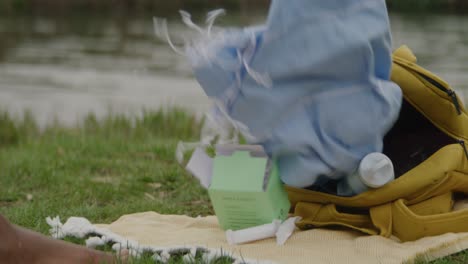 Mid-shot-of-bag-by-river-with-towel-being-pulled-out