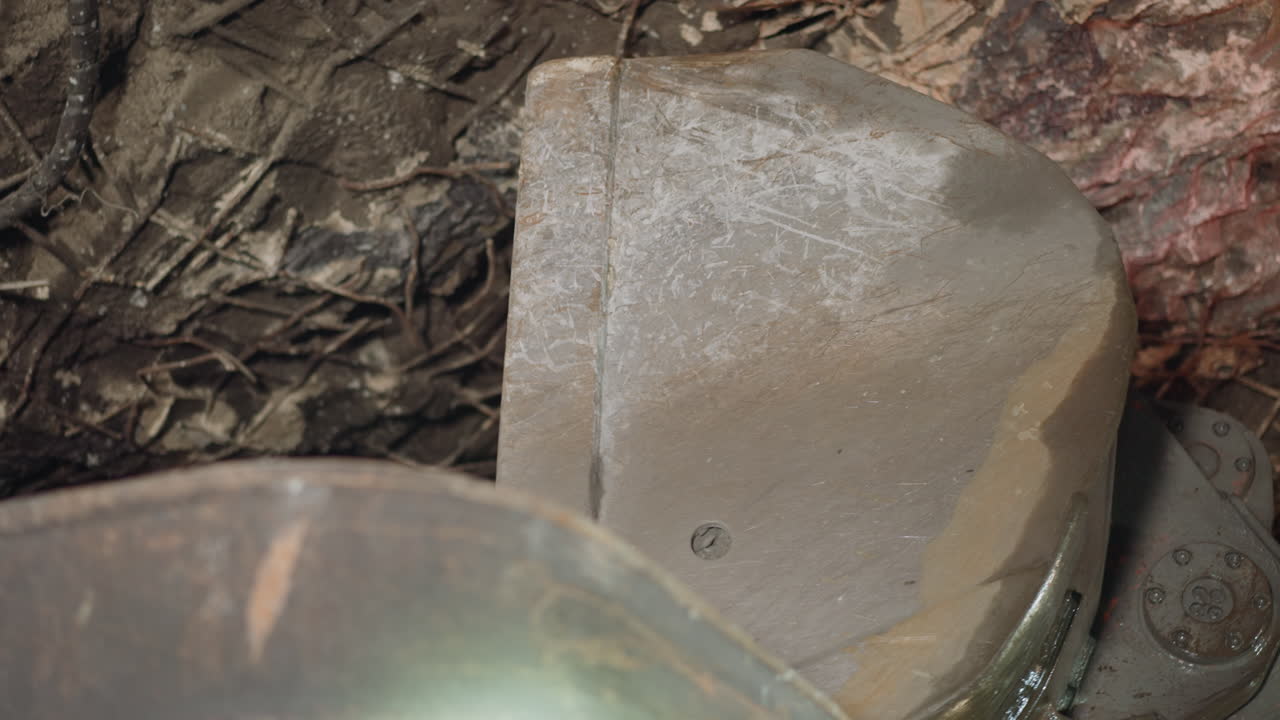 una máquina pesada descarga mineral de un gran depósito en un camión volqueteador