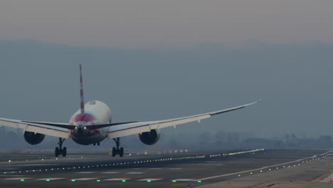 airplane landing on runway at dusk