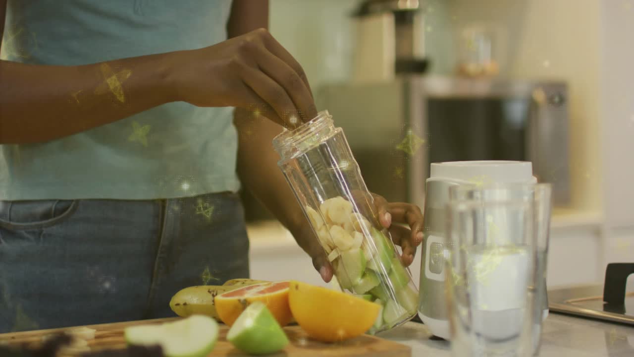 woman reaching across counter dropping fruit pieces into jar then placing jar on base for smoothie