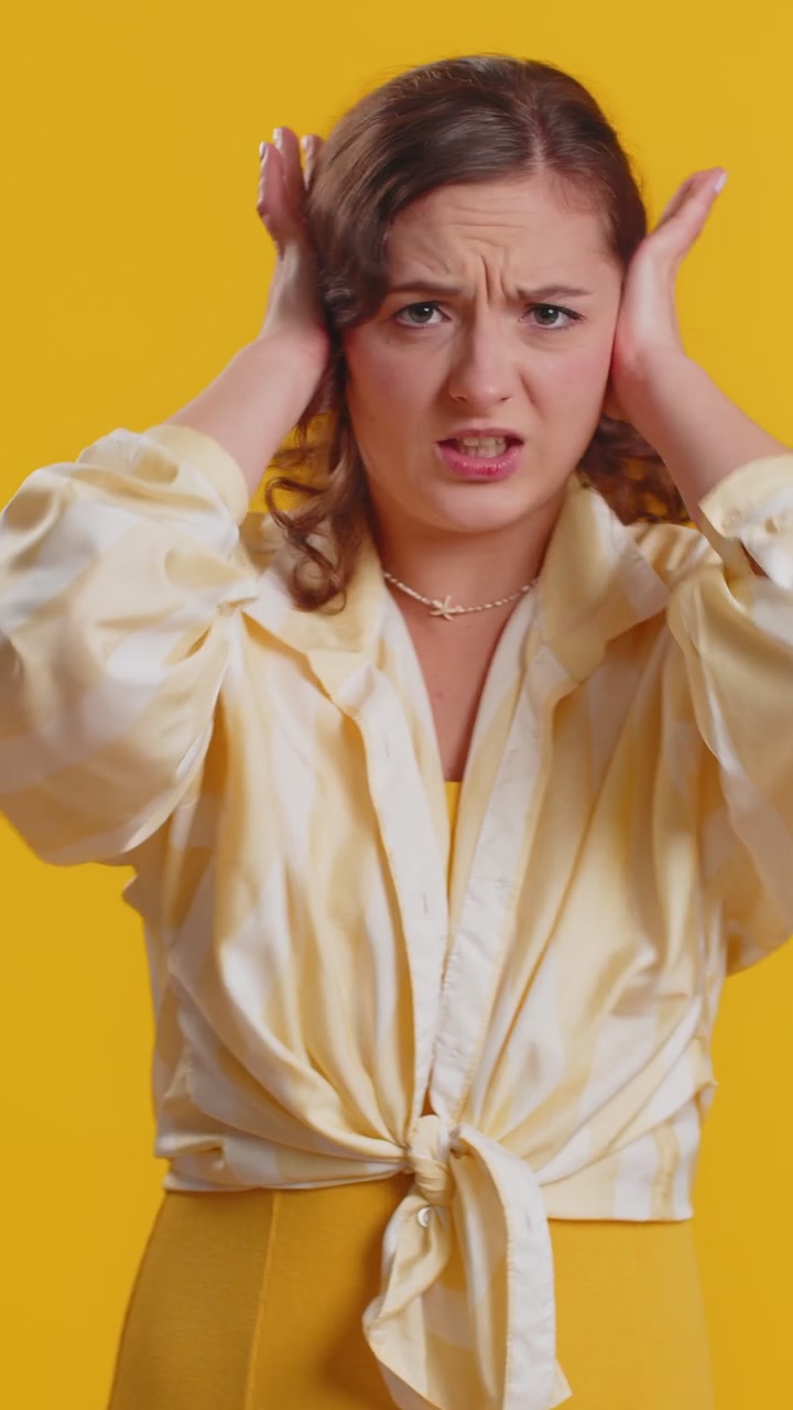 Ragazza irritata e irritata che copre le orecchie, che fa gesti, che non evita i consigli, che ignora il rumore, le voci forti.