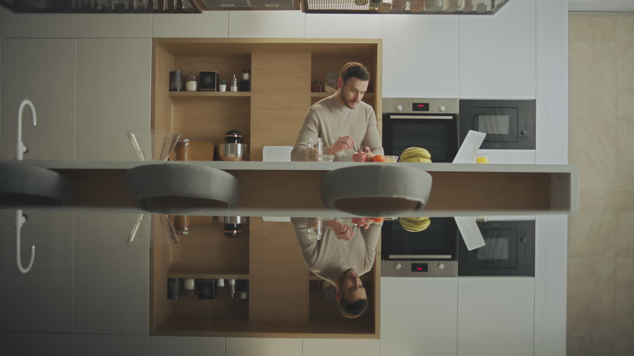 Uomo che fa colazione in una cucina moderna