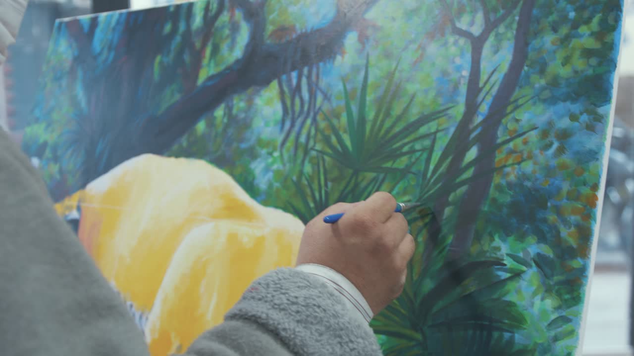 Professional artist painting details with brush on canvas Medium shot