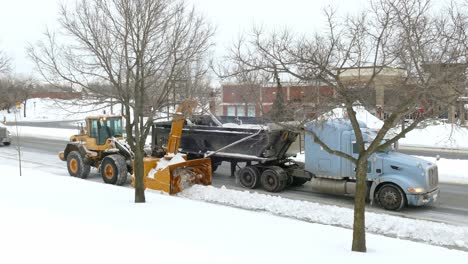 Statische-Ansicht-Des-Schneepflugs,-Der-Die-Straße-Räumt,-Indem-Schnee-Entfernt-Und-Auf-Einen-LKW-Geladen-Wird