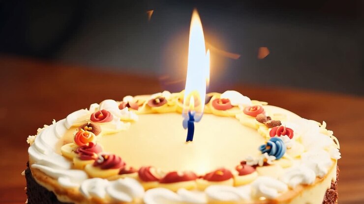 A birthday cake with one lit candle on top