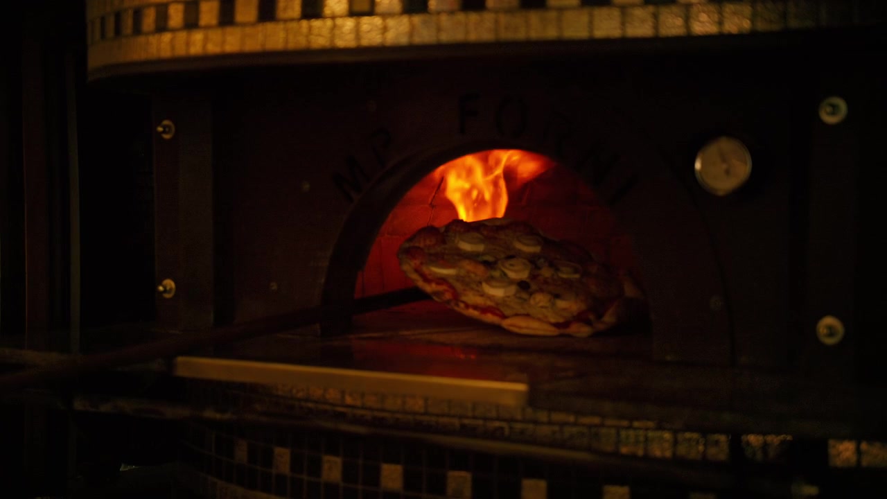Pizza tradicional assando em um forno a lenha quente com chamas fortes, criando deliciosa comida italiana. Preparando uma refeição.